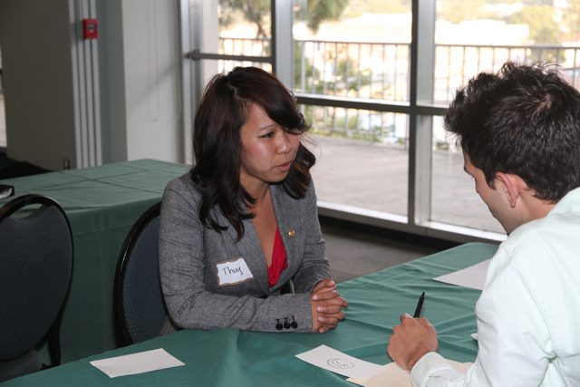 A man and woman talking at a table.