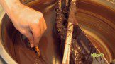 A person putting a hand in the chocolate mixing pot
