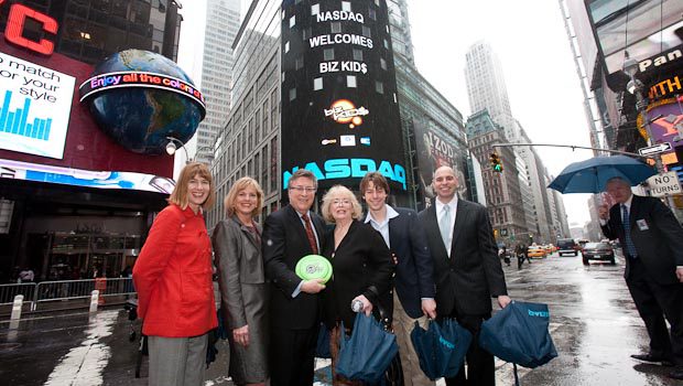 A group of people standing in front of a building in times square.