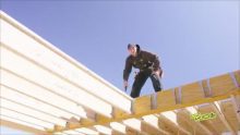 A man in a black outfit standing on a rooftop
