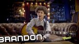 A boy sitting on the couch holding a guitar