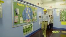 A man with a yellow hat leading small children
