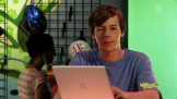 A young man sitting in front of a laptop computer.