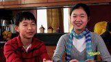 A boy and a girl with a blue scarf smiling