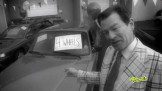a man pointing to the car with four wheels written on it.
