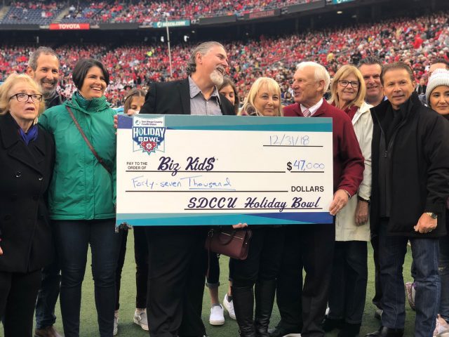 A group of people posing for a picture with a large check.
