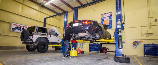 A man is working on a car in a garage.