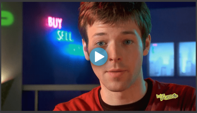 A young man in a red shirt is looking at the camera.