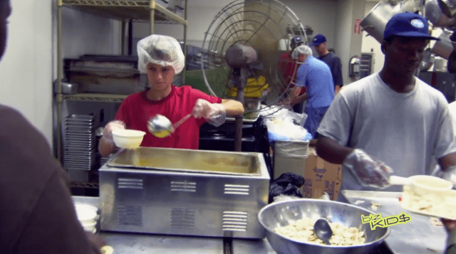 A group of people preparing food in a kitchen.