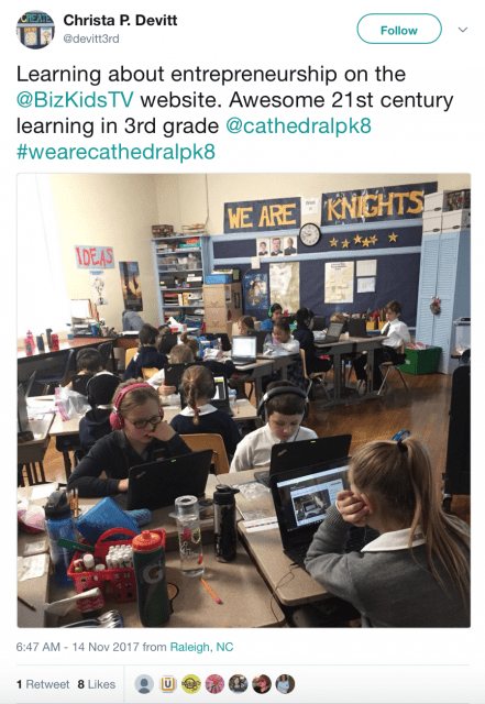 A group of students are using laptops to learn about entrepreneurship in the 21st century.