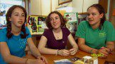 Three girls are talking to each other