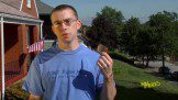 Man posing from lawn wearing blue tshirt