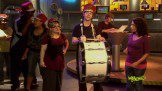 A group of people standing in front of a drum.