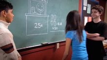 A group of people standing in front of a blackboard.