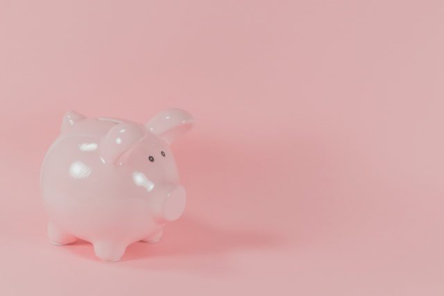A pink piggy bank on a pink background.