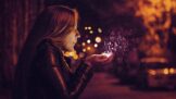 A woman is holding a sparkler in her hand.