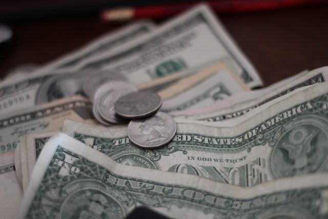 A stack of us dollar bills on a table.