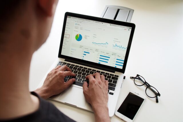 A man is using a laptop with a graph on it.